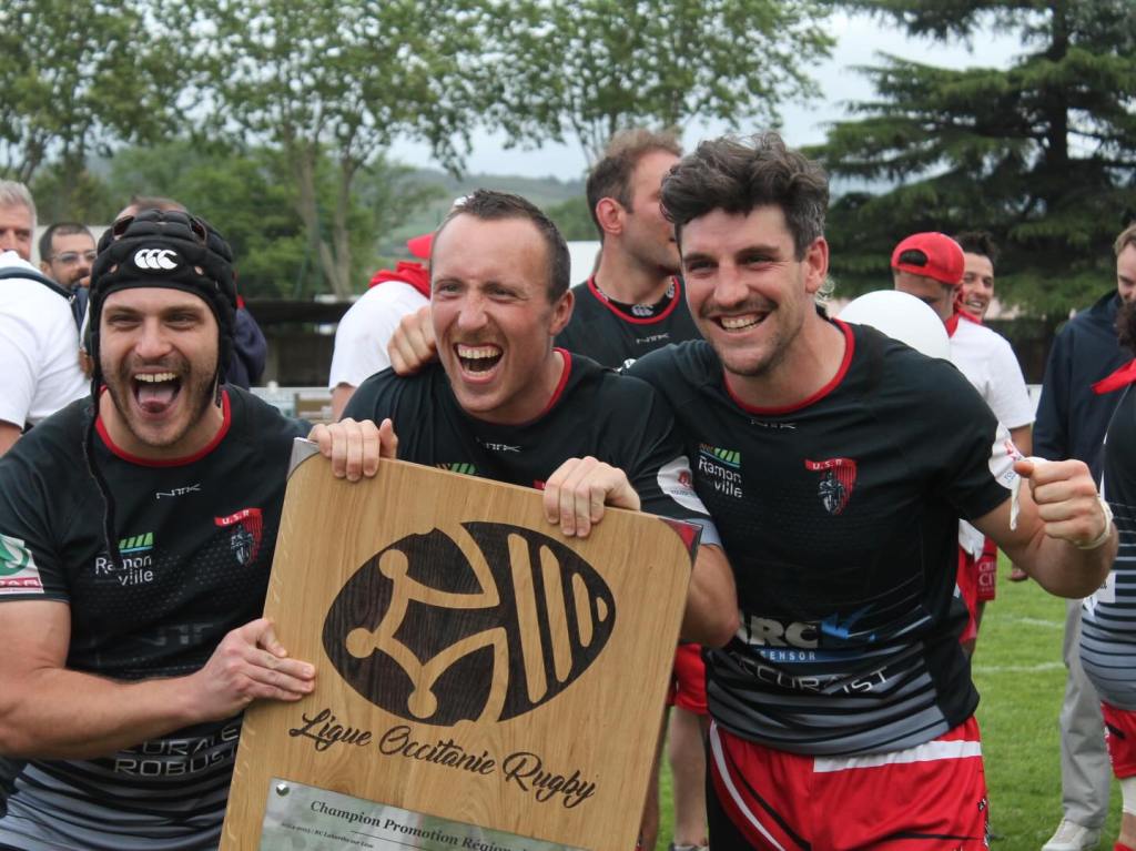 Le capitaine Pierre Loquet soulève le bouclier de champion d'Occitanie de Promotion Régionale 2, entouré de Paul Barthélémy et Antoine Souquet